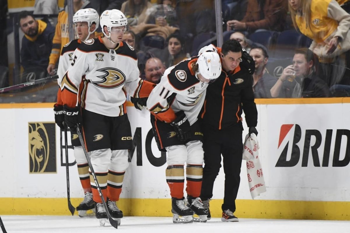Jan 9, 2024; Nashville, Tennessee, USA; Anaheim Ducks center Trevor Zegras (11) is helped off the ice after an injury first period against the Nashville Predators at Bridgestone Arena.