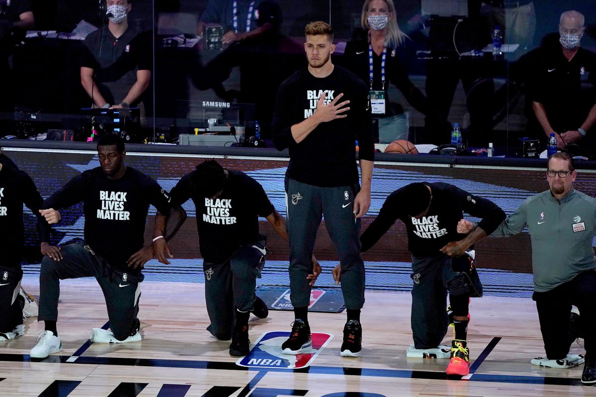 Me yers Leonard (then) of the Miami Heat stands during the National Anthem as his teammates take a knee.