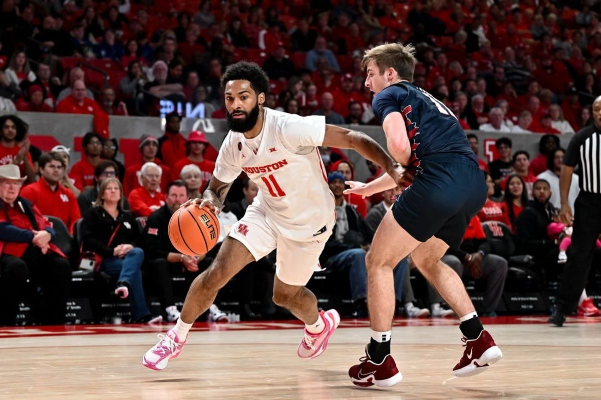 Dec 30, 2023; Houston, Texas, USA; Houston Cougars guard Damian Dunn (11) drives to the basket as Pennsylvania Quakers guard Sam Brown (11) defends during the first half at Fertitta Center.