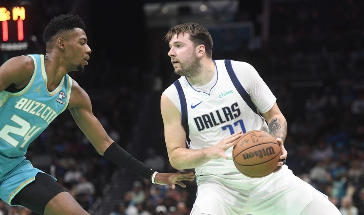 Apr 9, 2024; Charlotte, North Carolina, USA;  Dallas Mavericks guard Luka Doncic (77) looks to shoot while defended by Charlotte Hornets forward guard Brandon Miller (24) during the first half at the Spectrum Center.