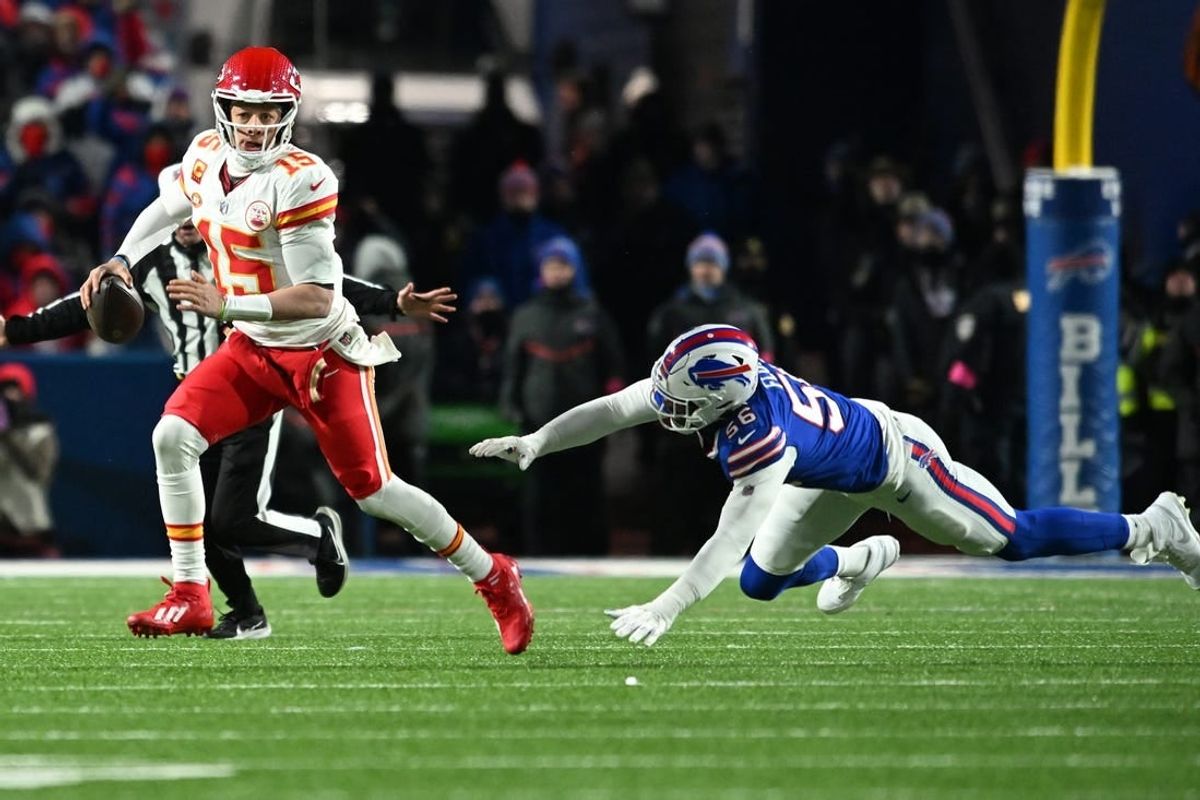 Jan 21, 2024; Orchard Park, New York, USA; Kansas City Chiefs quarterback Patrick Mahomes (15) rushes the ball past Buffalo Bills defensive end Leonard Floyd (56) in the second half of the 2024 AFC divisional round game at Highmark Stadium.