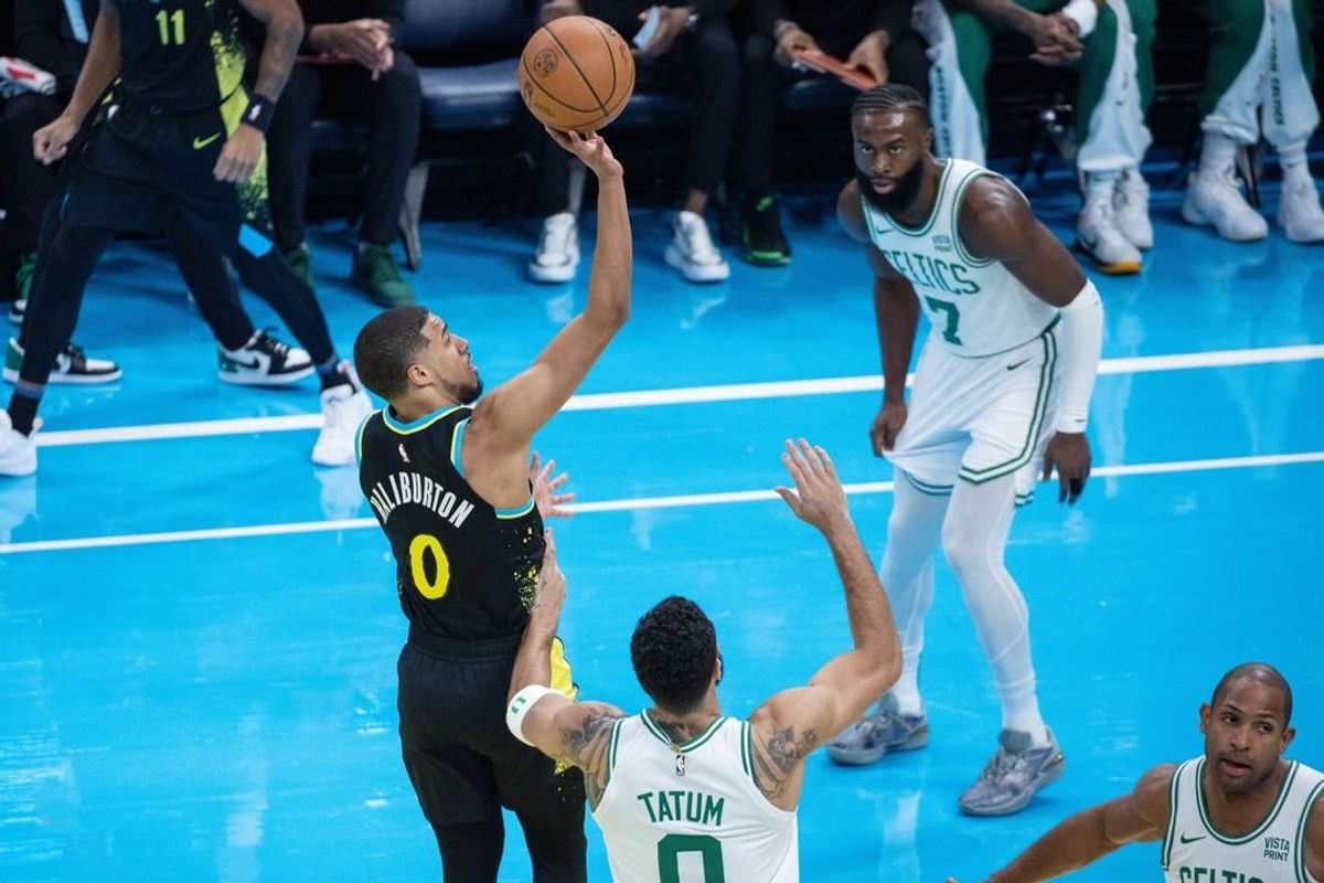 Dec 4, 2023; Indianapolis, Indiana, USA; Indiana Pacers guard Tyrese Haliburton (0) shoots while Boston Celtics forward Jayson Tatum (0)  defends in the first quarter at Gainbridge Fieldhouse.