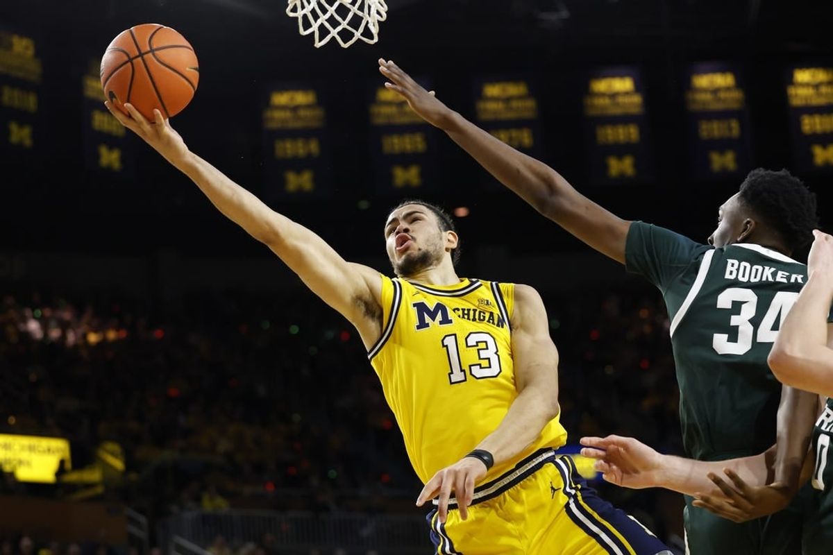 Feb 17, 2024; Ann Arbor, Michigan, USA; Michigan Wolverines forward Olivier Nkamhoua (13) shoots on Michigan State Spartans forward Xavier Booker (34) in the first half  at Crisler Center.