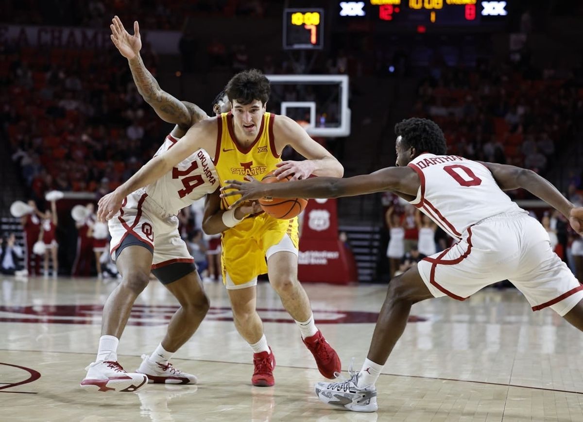 Jan 6, 2024; Norman, Oklahoma, USA; Iowa State Cyclones forward Milan Momcilovic (22) drives between Oklahoma Sooners forward Jalon Moore (14) and guard Le'Tre Darthard (0) during the first half at Lloyd Noble Center.