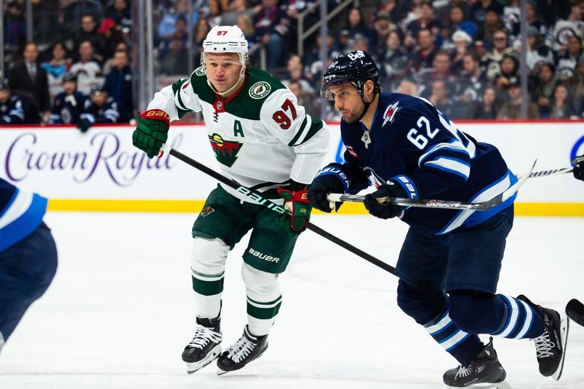 Feb 20, 2024; Winnipeg, Manitoba, CAN; Winnipeg Jets forward Nino Niederreiter (62) and Minnesota Wild forward Kirill Kaprizov (97) look for the puck during first period at Canada Life Centre.