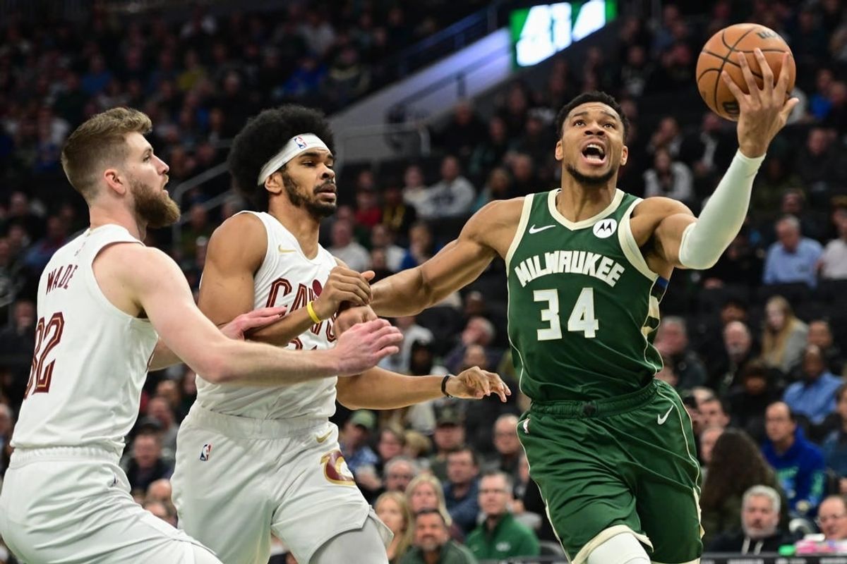 Jan 24, 2024; Milwaukee, Wisconsin, USA;  Milwaukee Bucks forward Giannis Antetokounmpo (34) takes a shot against Cleveland Cavaliers forward Dean Wade (32) and center Jarrett Allen (31) in the first quarter at Fiserv Forum.