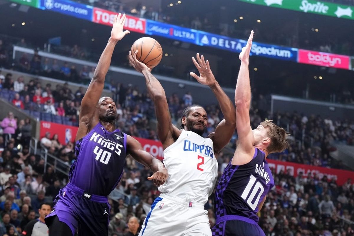 Feb 25, 2024; Los Angeles, California, USA; LA Clippers forward Kawhi Leonard (2) passes the ball against Sacramento Kings forward Harrison Barnes (40) and forward Domantas Sabonis (10) in the first half at Crypto.com Arena.