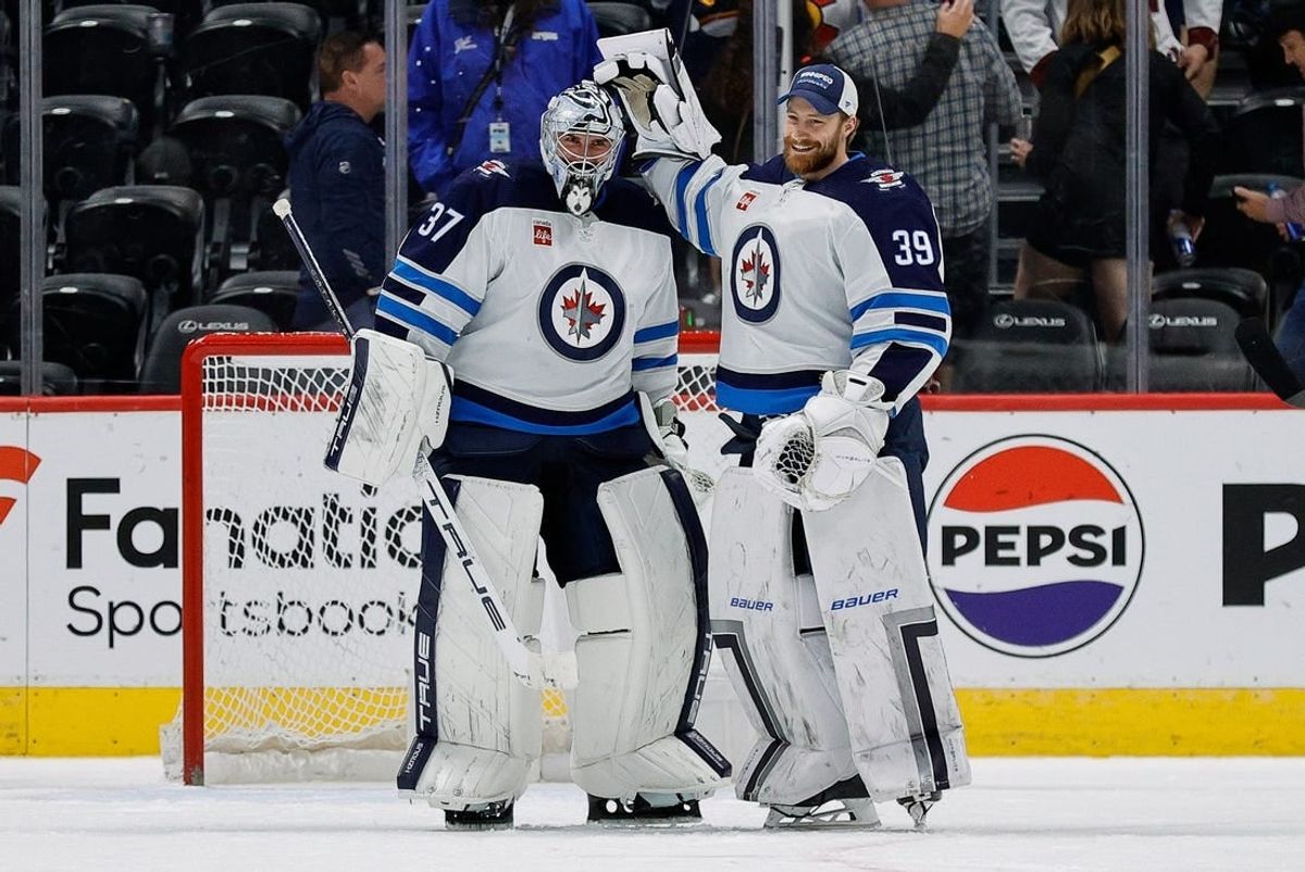 Apr 13, 2024; Denver, Colorado, USA; Winnipeg Jets goaltender Connor Hellebuyck (37) reacts with goaltender Laurent Brossoit (39) after the game against the Colorado Avalanche at Ball Arena.
