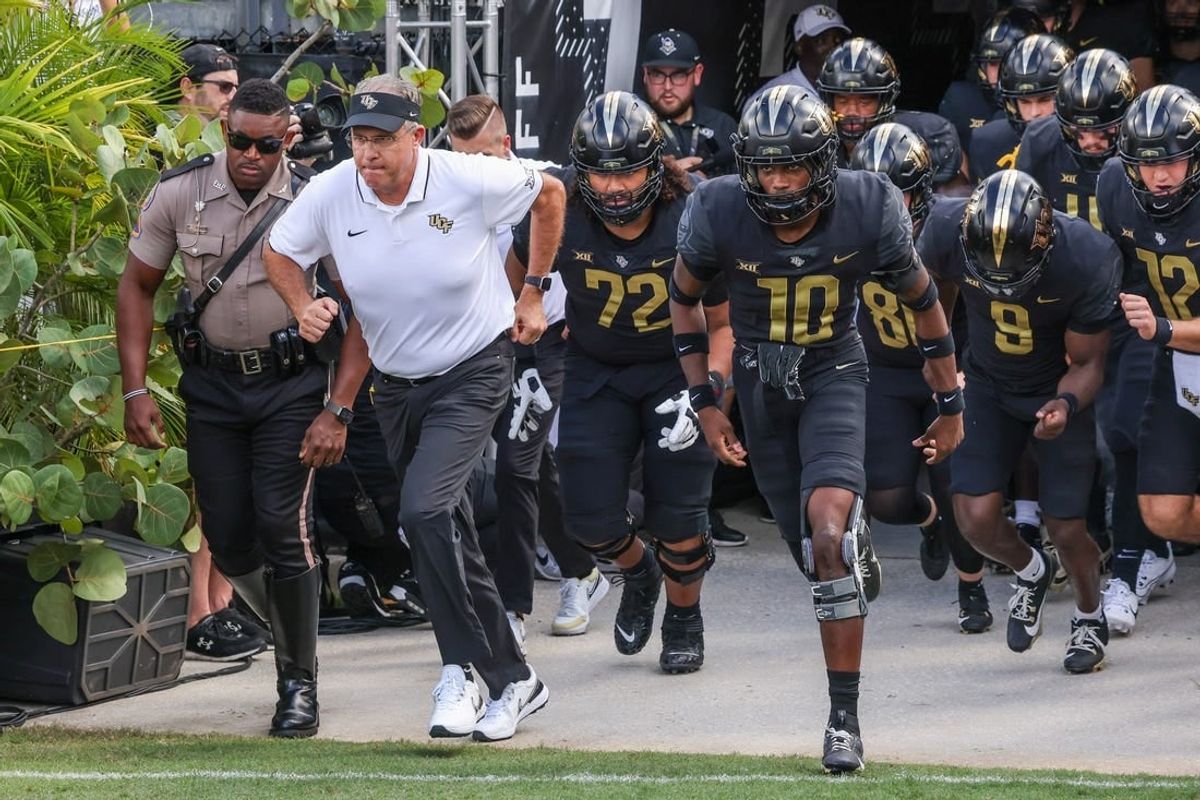 Sep 30, 2023; Orlando, Florida, USA; UCF Knights head coach Gus Malzahn and team run onto the field before the game against the Baylor Bears at FBC Mortgage Stadium.