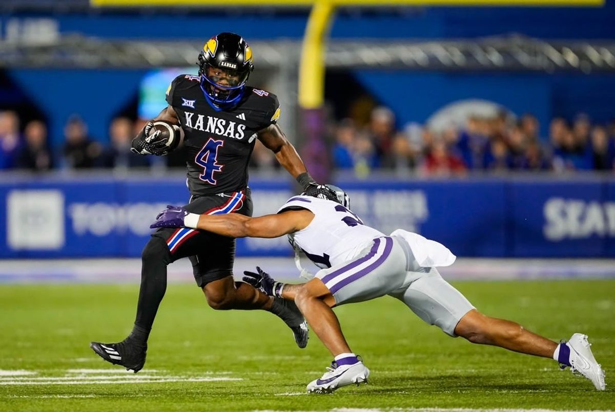 Nov 18, 2023; Lawrence, Kansas, USA; Kansas Jayhawks running back Devin Neal (4) runs the ball against Kansas State Wildcats safety Marques Sigle (21) during the first half at David Booth Kansas Memorial Stadium.