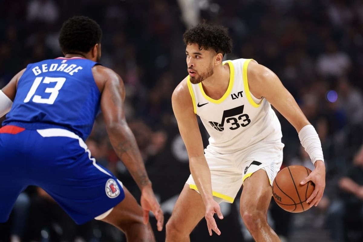 Apr 12, 2024; Los Angeles, California, USA;  Utah Jazz guard Johnny Juzang (33) dribbles the ball against Los Angeles Clippers forward Paul George (13) during the first quarter at Crypto.com Arena.
