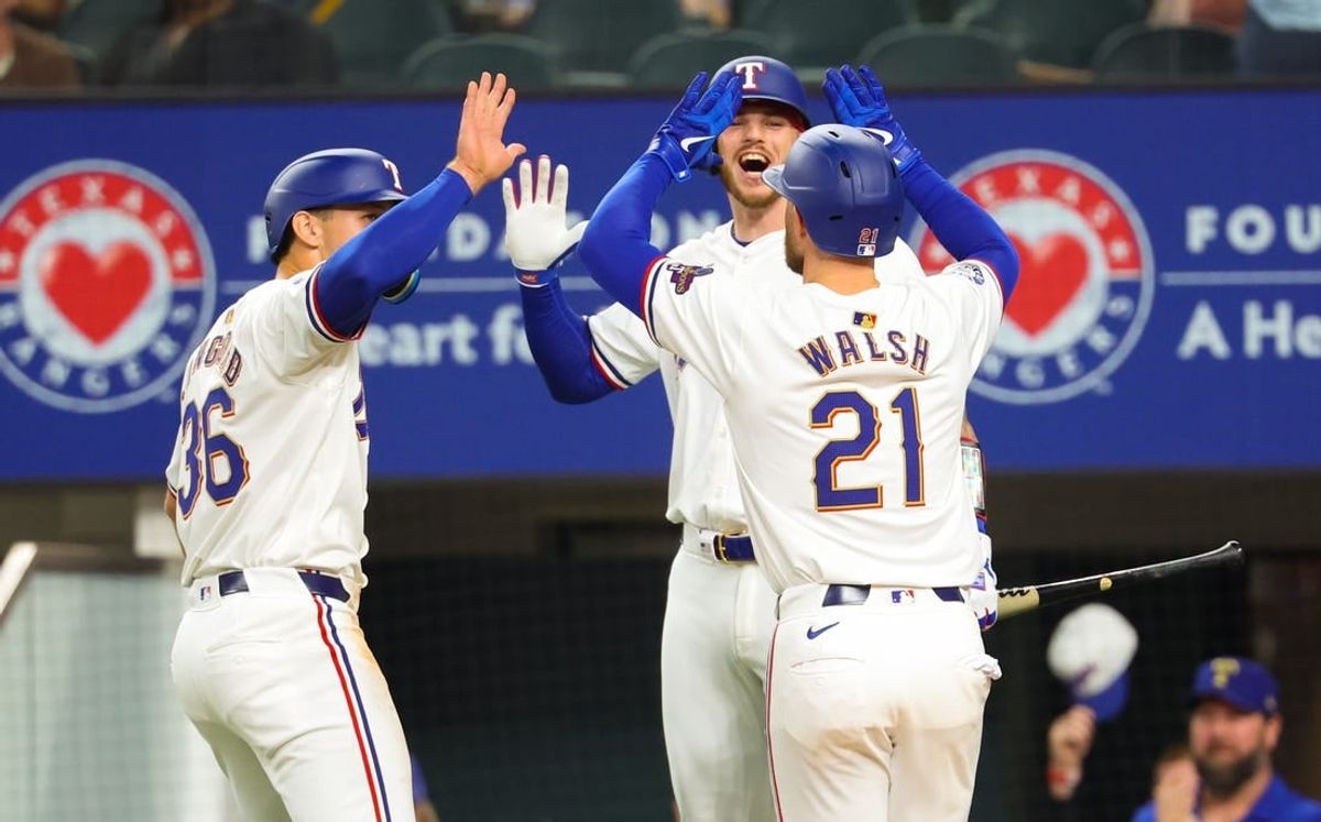 Mar 30, 2024; Arlington, Texas, USA;  Texas Rangers first baseman Jared Walsh (21) celebrates with Texas Rangers designated hitter Wyatt Langford (36) and Texas Rangers catcher Jonah Heim (28) after hitting a two-run home run during the second inning against the Chicago Cubs at Globe Life Field.
