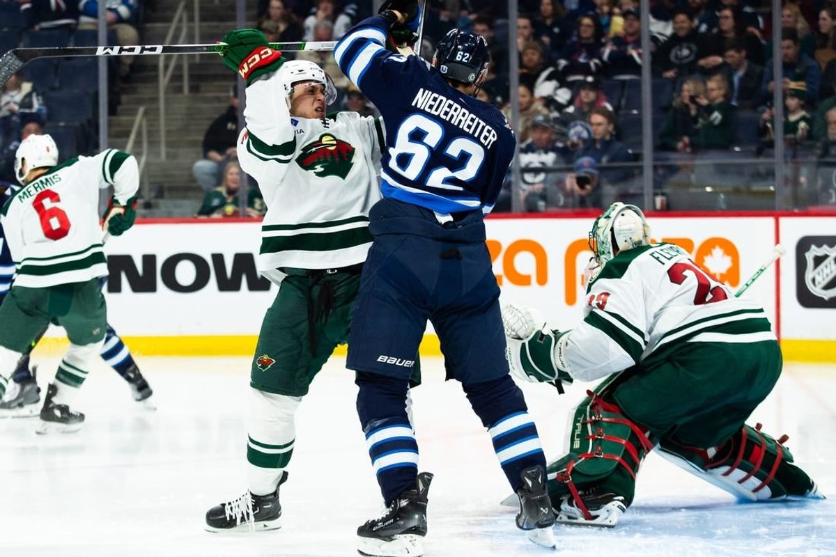Feb 20, 2024; Winnipeg, Manitoba, CAN; Winnipeg Jets forward Nino Niederreiter (62) jostles for position with Minnesota Wild defenseman Alex Goligoski (33) during the second period at Canada Life Centre.