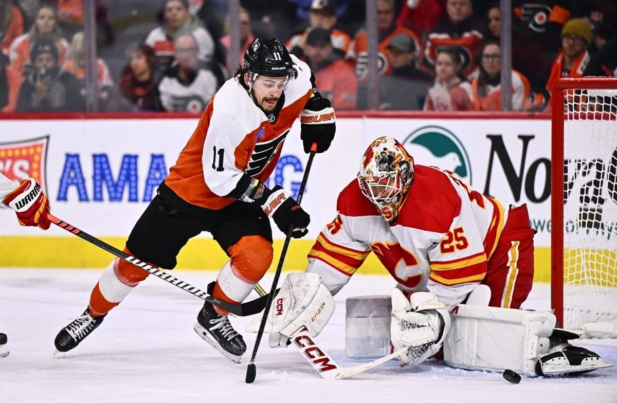 Jan 6, 2024; Philadelphia, Pennsylvania, USA; Philadelphia Flyers right wing Travis Konecny (11) dives for the puck against Calgary Flames goalie Jacob Markstrom (25) in the second period at Wells Fargo Center.