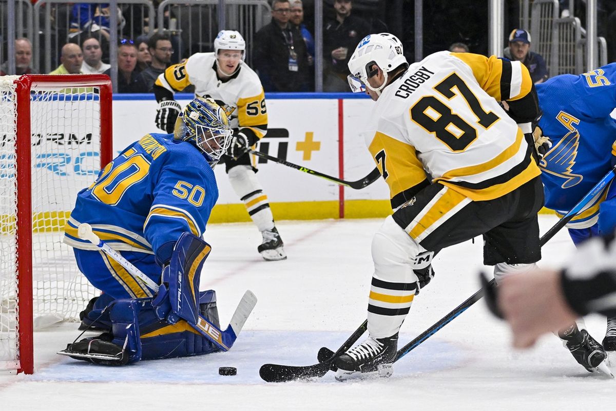 Feb 25, 2023; St. Louis, Missouri, USA;  St. Louis Blues goaltender Jordan Binnington (50) defends the net against Pittsburgh Penguins center Sidney Crosby (87) during the first period at Enterprise Center. Mandatory Credit: Jeff Curry-Imagn Images