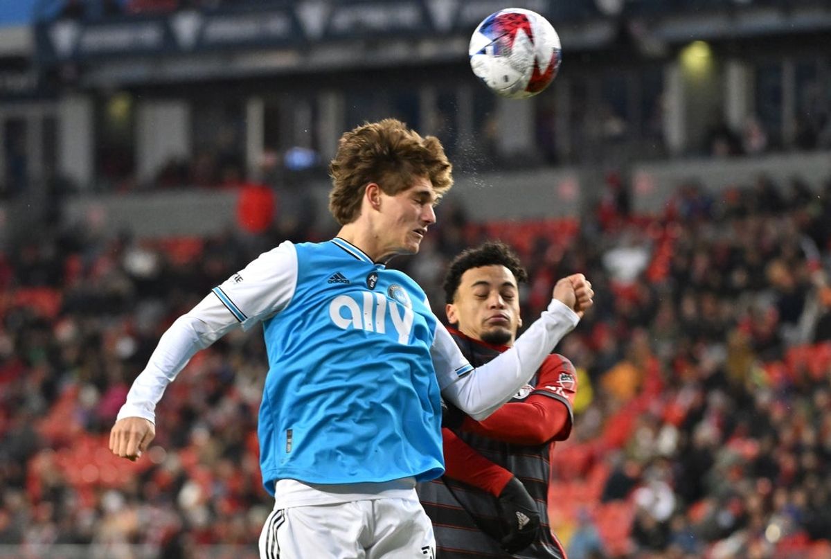 Apr 1, 2023; Toronto, Ontario, CAN;   Charlotte FC midfielder Ben Bender (15) heads the ball over Toronto FC midfielder Brandon Servania (23) in the first half at BMO Field. Mandatory Credit: Dan Hamilton-Imagn Images
