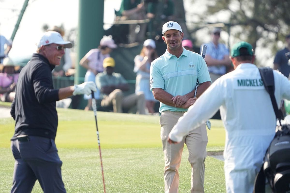Apr 5, 2023; Augusta, Georgia, USA; Phil Mickelson (left) and Bryson DeChambeau (center) talk on the third hole during a practice round for The Masters golf tournament at Augusta National Golf Club. Mandatory Credit: Kyle Terada-USA TODAY Network
