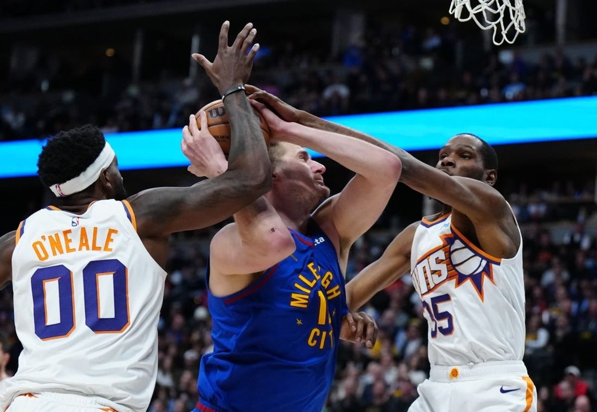 Mar 5, 2024; Denver, Colorado, USA; Phoenix Suns forward Kevin Durant (35) and forward Royce O'Neale (00) defend Denver Nuggets center Nikola Jokic (15) in the first half at Ball Arena.