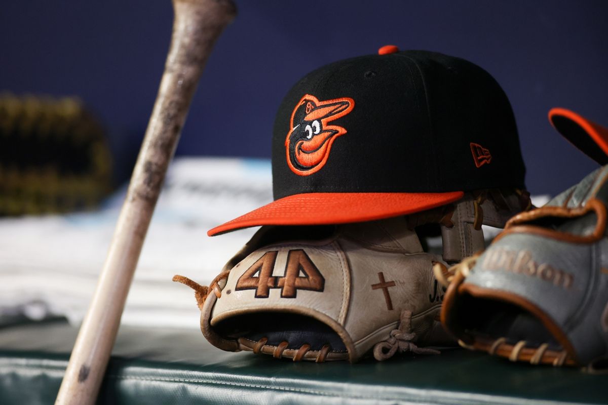 May 5, 2023; Atlanta, Georgia, USA; A detailed view of a Baltimore Orioles hat and glove in the dugout during a game against the Atlanta Braves in the seventh inning at Truist Park. Mandatory Credit: Brett Davis-USA TODAY Sports