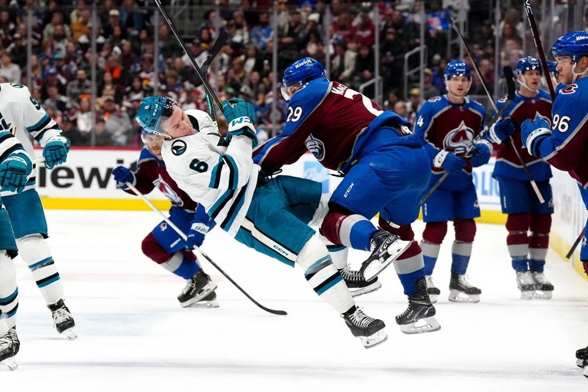 Dec 31, 2023; Denver, Colorado, USA; Colorado Avalanche center Nathan MacKinnon (29) hits San Jose Sharks defenseman Ty Emberson (6) in the second period at Ball Arena.