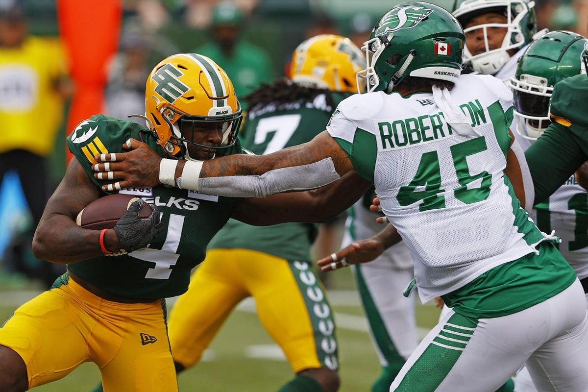 Jun 11, 2023; Edmonton, Alberta, CAN; Saskatchewan Roughriders defensive lineman Pete Robertson (45) attempts to tackle Edmonton Elks running back Kevin Brown (4) during the first half at Commonwealth Stadium. Mandatory Credit: Perry Nelson-USA TODAY Sports