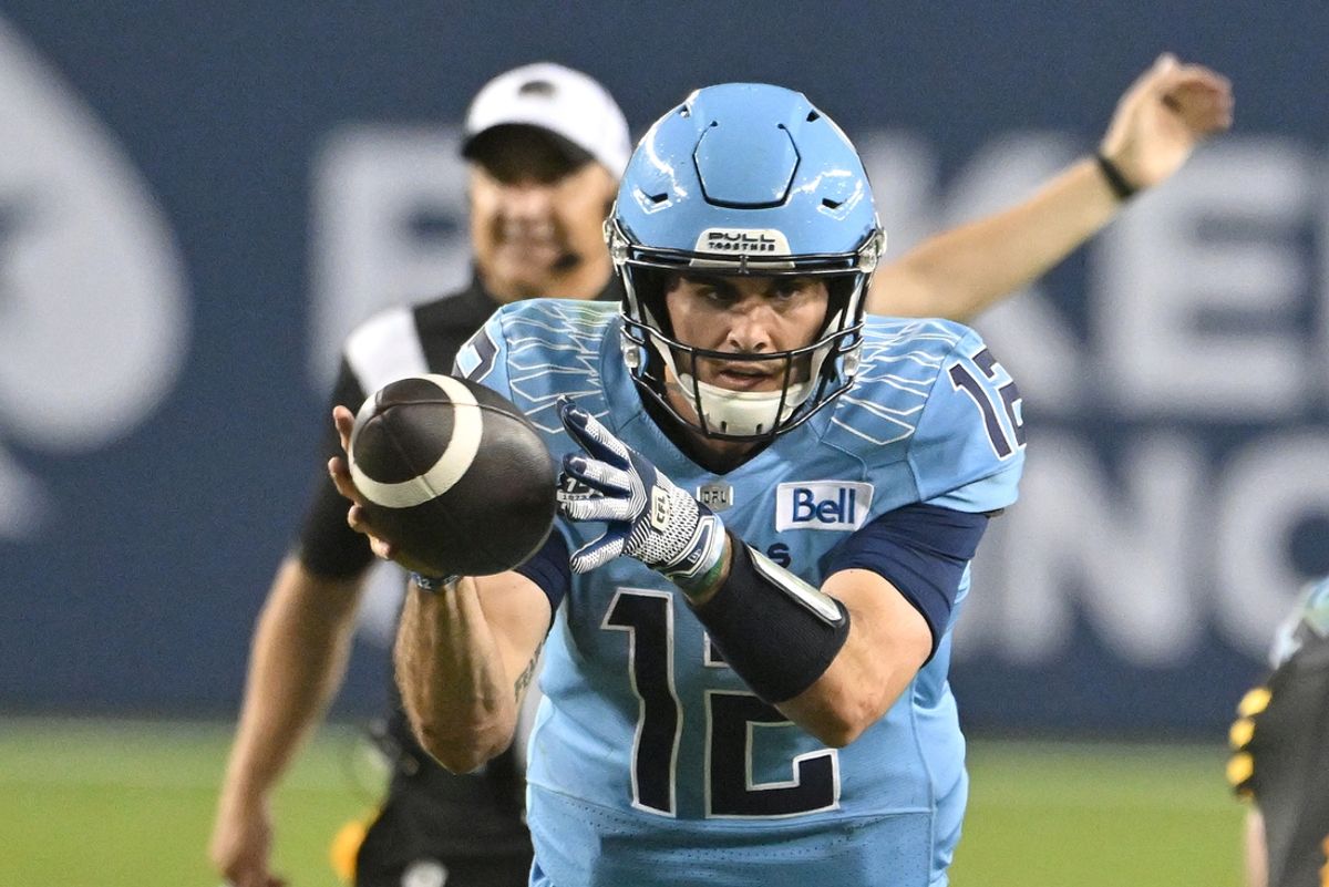 Jun 18, 2023; Toronto, Ontario, CAN;  Toronto Argonauts quarterback Chad Kelly (12) takes a snap in the fourth  quarter against the Hamilton Tiger-Cats at BMO Field. Mandatory Credit: Dan Hamilton-Imagn Images