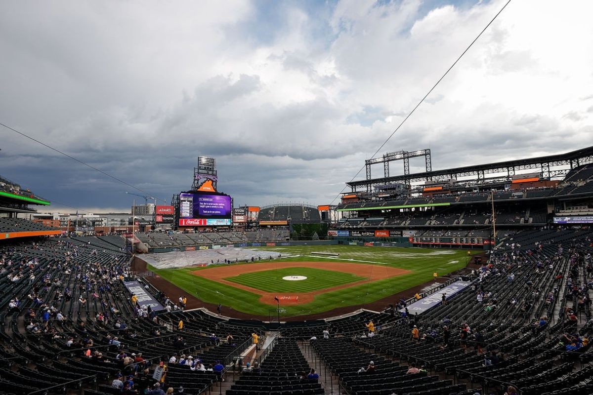 Jun 29, 2023; Denver, Colorado, USA; Grounds crew clear the infield tarp during a rain delay before the game between the Colorado Rockies and the Los Angeles Dodgers at Coors Field. Mandatory Credit: Isaiah J. Downing-Imagn Images