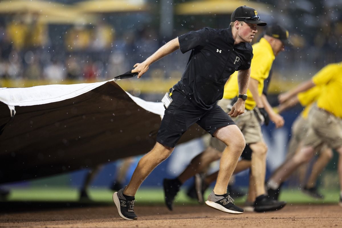 Jul 1, 2023; Pittsburgh, Pennsylvania, USA; The Pittsburgh Pirates grounds crew pull the tarp onto the field during a rain delay in the ninth inning against the Milwaukee Brewers at PNC Park. Mandatory Credit: Scott Galvin-Imagn Images