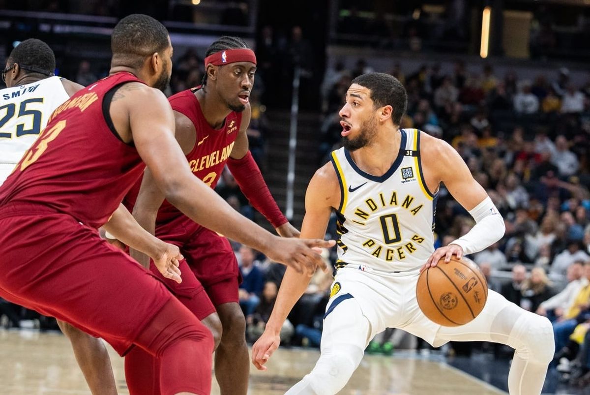 Mar 18, 2024; Indianapolis, Indiana, USA; Indiana Pacers guard Tyrese Haliburton (0) dribbles the ball while Cleveland Cavaliers guard Caris LeVert (3) defends in the first half at Gainbridge Fieldhouse.