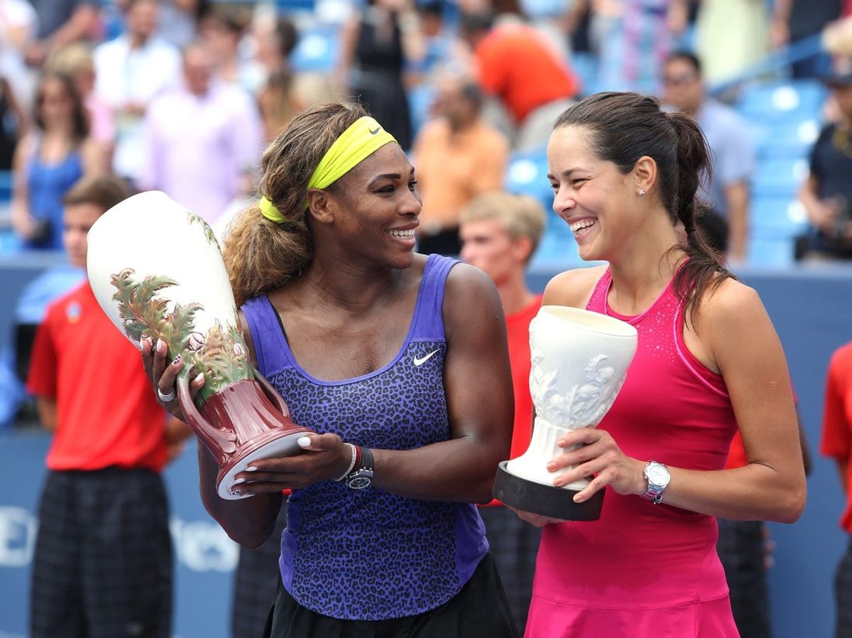 Serena Williams, left, Ana Ivanovic laugh while posing with their trophes from the Western and Southern Open Sunday. Williams beat Ivanovic, 6-4, 6-1 at the Lindner Family Tennis Center in Mason. Photo shot Sunday August 17, 2014.