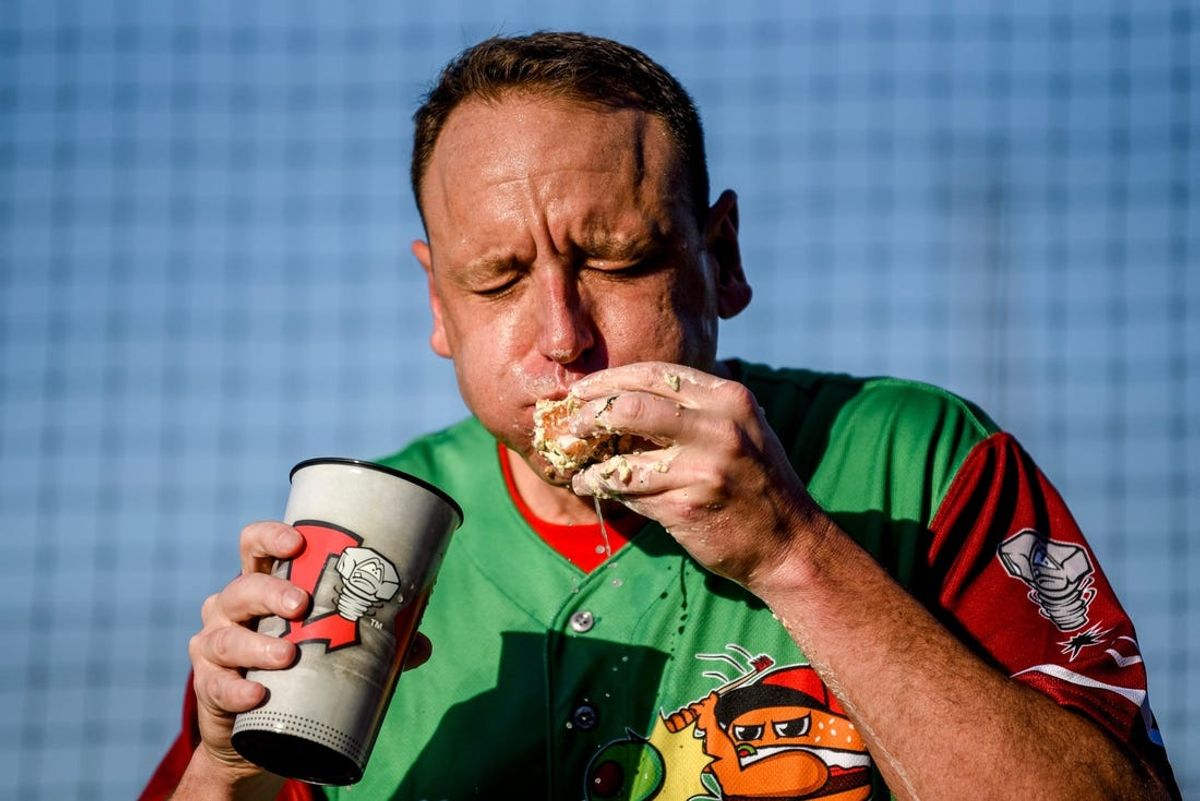 Nathan's Hot Dog Eating champion Joey Chestnut eats an olive burgers before the Lugnuts game against the TinCaps on Thursday, Aug. 10, 2023, at Jackson Field in Lansing. Chestnut set a record with 13 olive burgers eaten in 5 minutes.