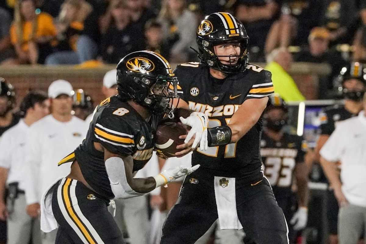 Aug 31, 2023; Columbia, Missouri, USA; Missouri Tigers quarterback Sam Horn (21) hands off to running back Nathaniel Peat (8) against the South Dakota Coyotes during the second half at Faurot Field at Memorial Stadium. Mandatory Credit: Denny Medley-Imagn Images