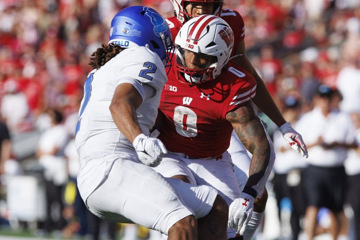 Sep 2, 2023; Madison, Wisconsin, USA;  Wisconsin Badgers running back Braelon Allen (0) rushes with the football as Buffalo Bulls linebacker Red Murdock (2) defends during the third quarter at Camp Randall Stadium. Mandatory Credit: Jeff Hanisch-Imagn Images