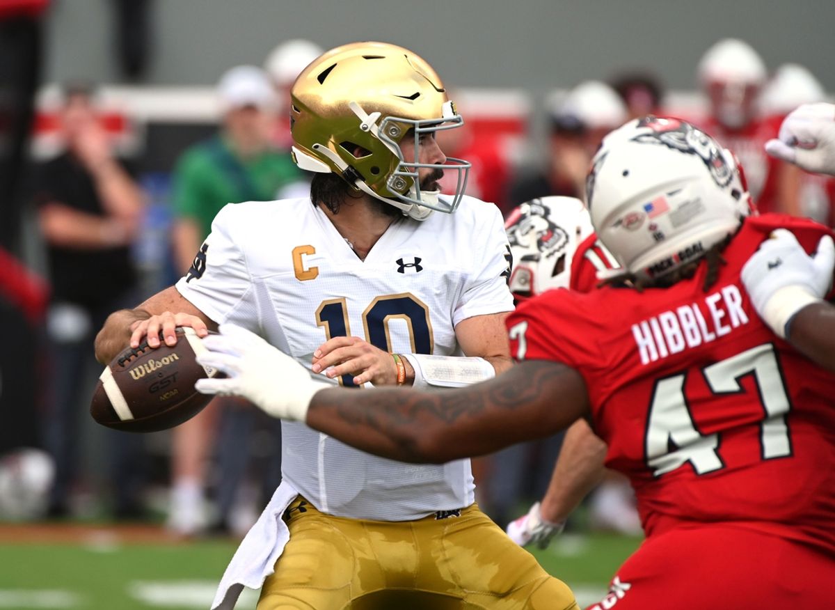 Sep 9, 2023; Raleigh, North Carolina, USA; Notre Dame Fighting Irish quarterback Sam Hartman (10) looks to pass as he is pressured by North Carolina State Wolfpack defensive lineman Jykeveous Red Hibbler(47) during the first half  at Carter-Finley Stadium. Mandatory Credit: Rob Kinnan-Imagn Images