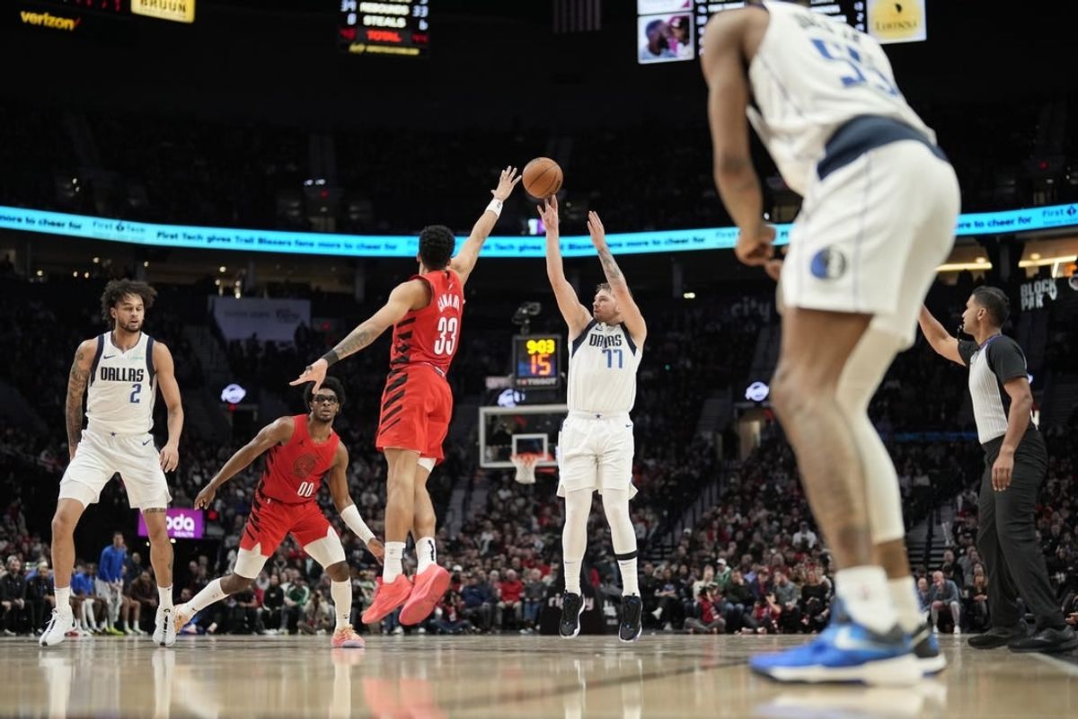 Dec 8, 2023; Portland, Oregon, USA; Dallas Mavericks point guard Luka Doncic (77) shoots the ball over Portland Trail Blazers forward Toumani Camara (33) during the second half at Moda Center.
