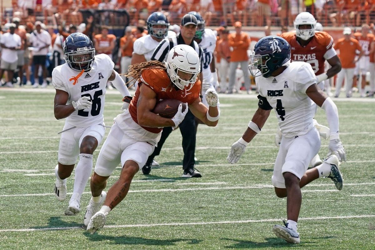 Sep 2, 2023; Austin, Texas, USA; Texas Longhorns wide receiver Jordan Whittington (13) is chased by Rice Owls defensive back Marcus Williams (4) and Gabriel Taylor (26) after making a catch during the first half against the  at Darrell K Royal-Texas Memorial Stadium. Mandatory Credit: Scott Wachter-Imagn Images