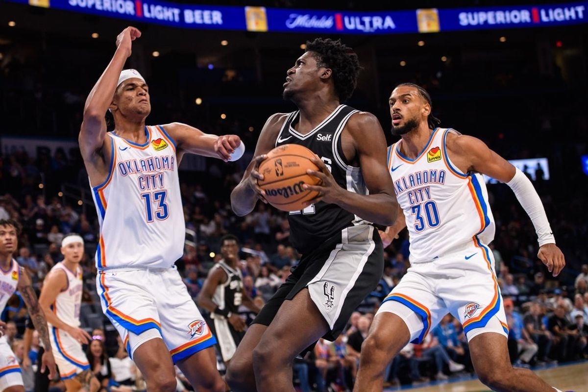Oct 9, 2023; Oklahoma City, Oklahoma, USA; San Antonio Spurs center Charles Bediako (27) goes to the basket while defended by Oklahoma City Thunder forward Ousmane Dieng (13) during the second half at Paycom Center. Mandatory Credit: Rob Ferguson-Imagn Images