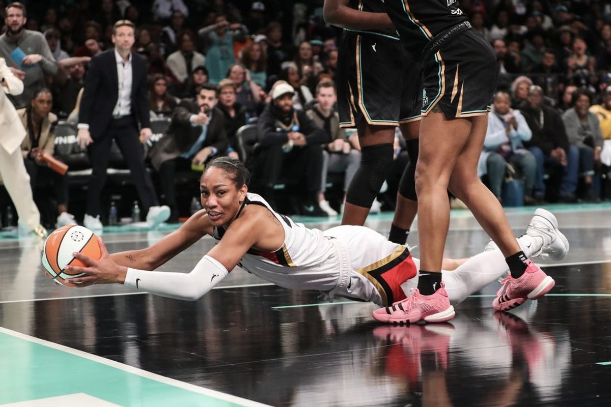 Oct 15, 2023; Brooklyn, New York, USA; Las Vegas Aces forward A'ja Wilson (22) falls to the floor with the ball in the second quarter against the New York Liberty during game three of the 2023 WNBA Finals at Barclays Center. Mandatory Credit: Wendell Cruz-USA TODAY Sports