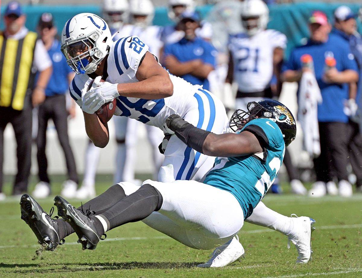 Oct 15, 2023; Jacksonville, Florida, USA; Indianapolis Colts running back Jonathan Taylor (28) is tackled by Jacksonville Jaguars linebacker Foyesade Oluokun (23) during the game at EverBank Stadium. Mandatory Credit: Melina Myers-Imagn Images