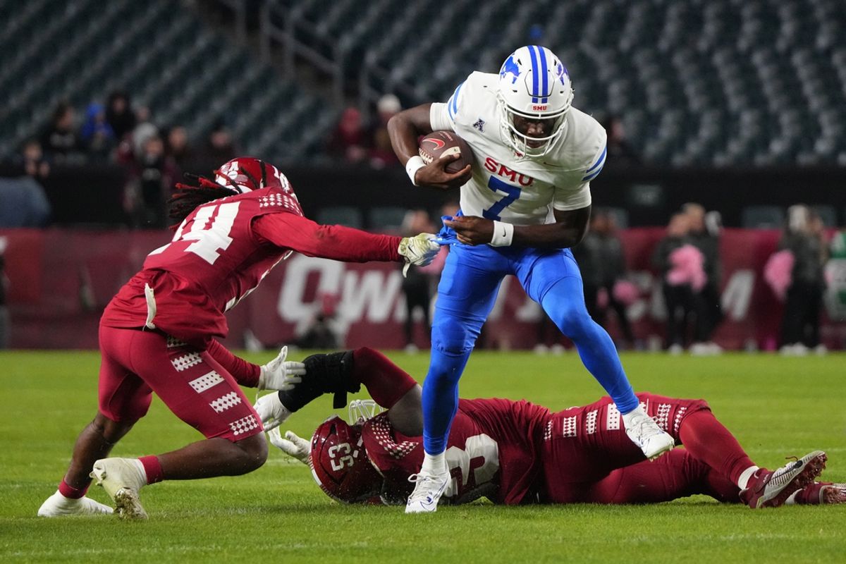 Oct 20, 2023; Philadelphia, Pennsylvania, USA; SMU Mustangs quarterback Kevin Jennings (7) runs with the ball against Temple Owls safety Brenyen Scott (14) during the second half at Lincoln Financial Field. Mandatory Credit: Gregory Fisher-Imagn Images