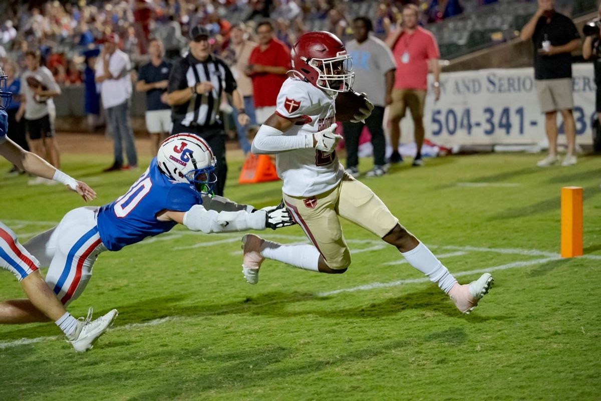 Oct 27, 2023; Metairie, LA, USA; Brother Martin Crusaders wide receiver Easton Royal (23) scores a touchdown against John Curtis Patriots linebacker Benjamin Barron (30) during the first quarter at The Shrine on Airline. Mandatory Credit: Matthew Hinton-Imagn Images