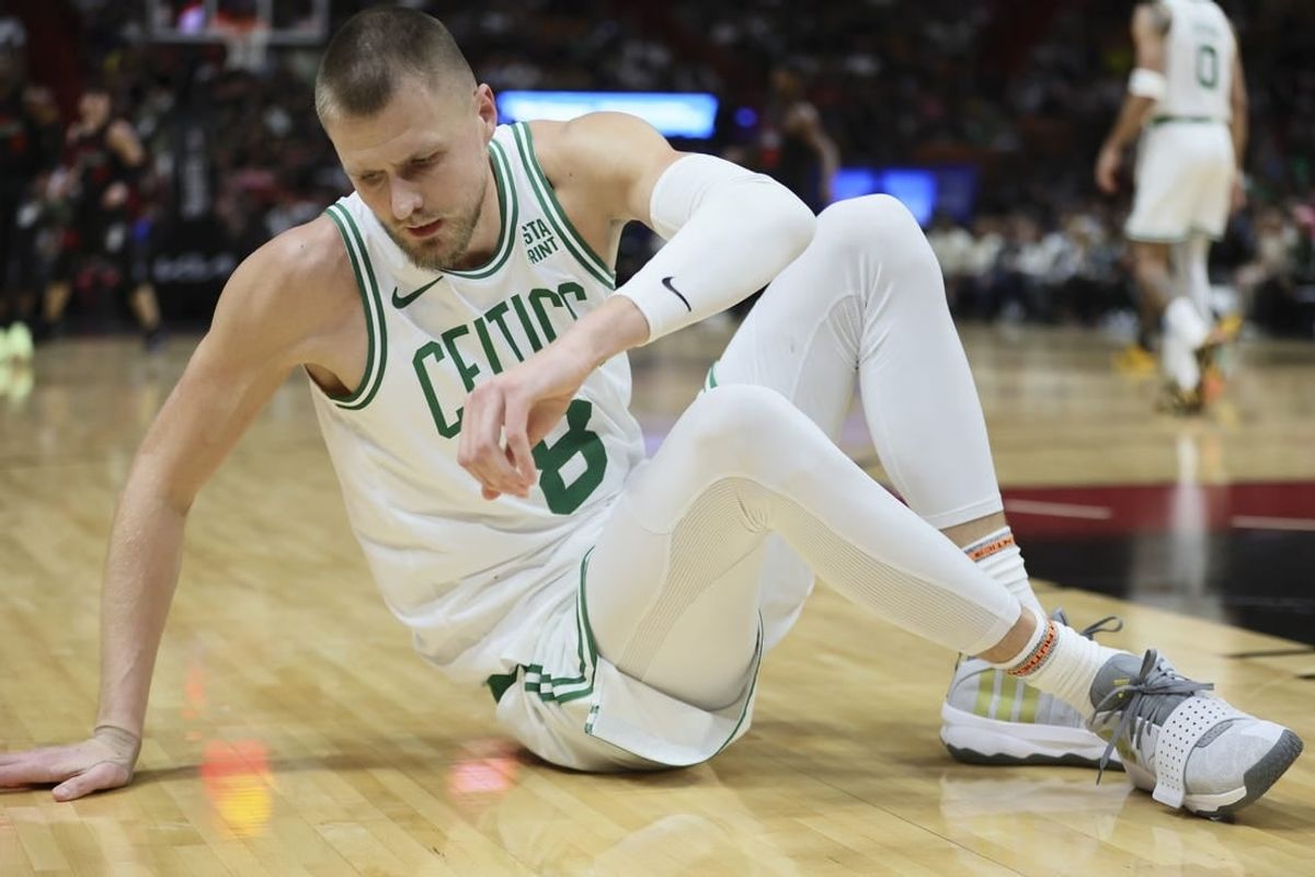 Jan 25, 2024; Miami, Florida, USA; Boston Celtics center Kristaps Porzingis (8) reacts on the floor after a play against the Miami Heat during the third quarter at Kaseya Center.