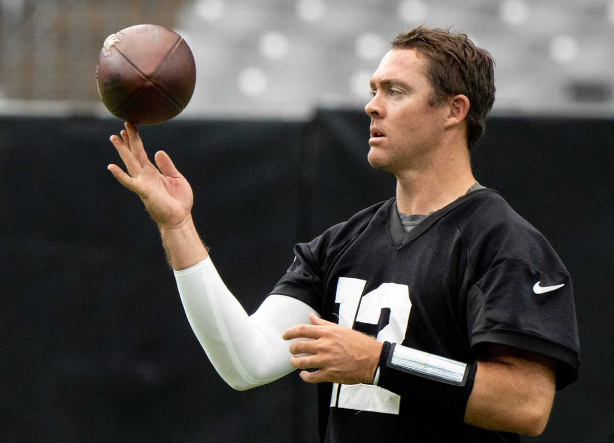QB Colt McCoy spins a football during training camp at State Farm Stadium in Glendale on July 31, 2023.
