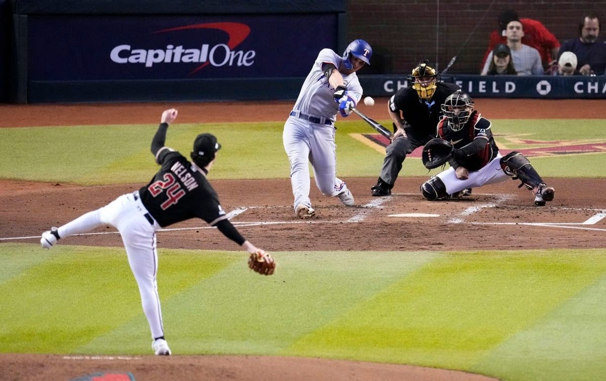 Oct 31, 2023; Phoenix, AZ, USA; Texas Rangers shortstop Corey Seager (5) hits a two-run home run off of Arizona Diamondbacks relief pitcher Kyle Nelson (24) during the second inning during Game 4 in the World Series at Chase Field. Mandatory Credit: Rob Schumacher-Arizona Republic