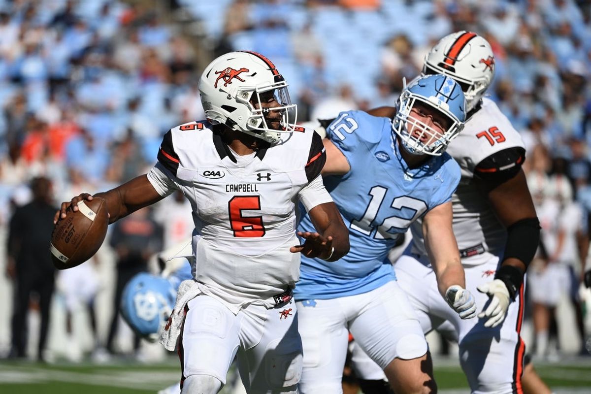 Nov 4, 2023; Chapel Hill, North Carolina, USA;  Campbell Fighting Camels quarterback Hajj-Malik Williams (6) looks to pass as North Carolina Tar Heels defensive lineman Beau Atkinson (12) pressures in the third quarter at Kenan Memorial Stadium. Mandatory Credit: Bob Donnan-Imagn Images