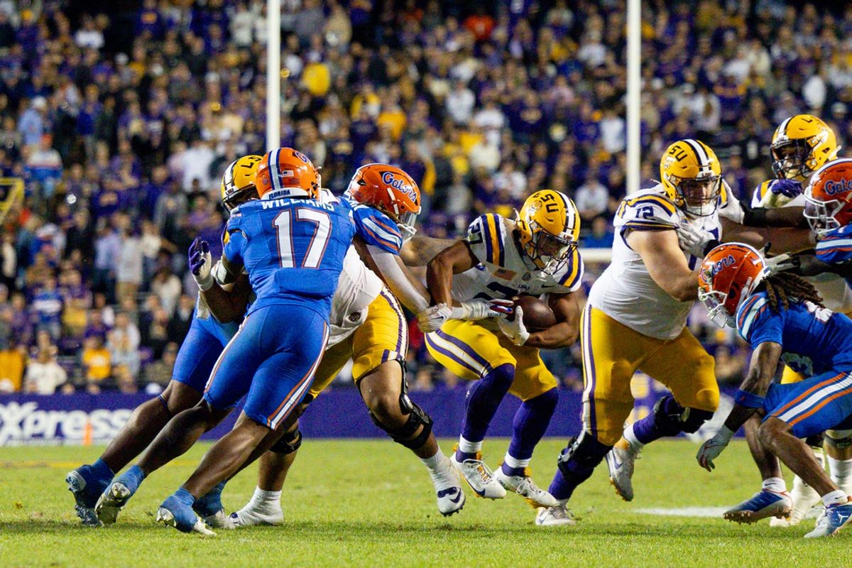 Nov 11, 2023; Baton Rouge, Louisiana, USA;  LSU Tigers running back Josh Williams (27) rushes against Florida Gators linebacker Scooby Williams (17) during the second half at Tiger Stadium. Mandatory Credit: Stephen Lew-Imagn Images