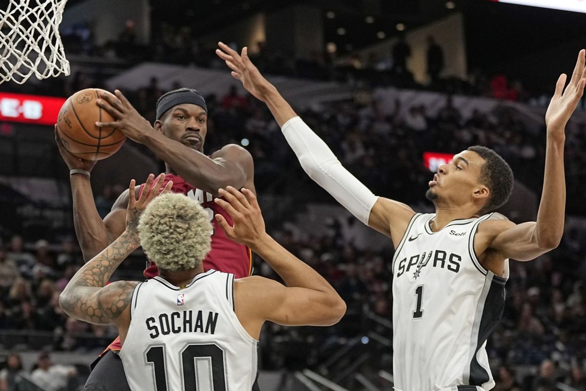 Nov 12, 2023; San Antonio, Texas, USA; Miami Heat forward Jimmy Butler (22) looks to pass the ball while defended by San Antonio Spurs forwards Victor Wembanyama (1) and Jeremy Sochan (10) at Frost Bank Center. Mandatory Credit: Scott Wachter-Imagn Images