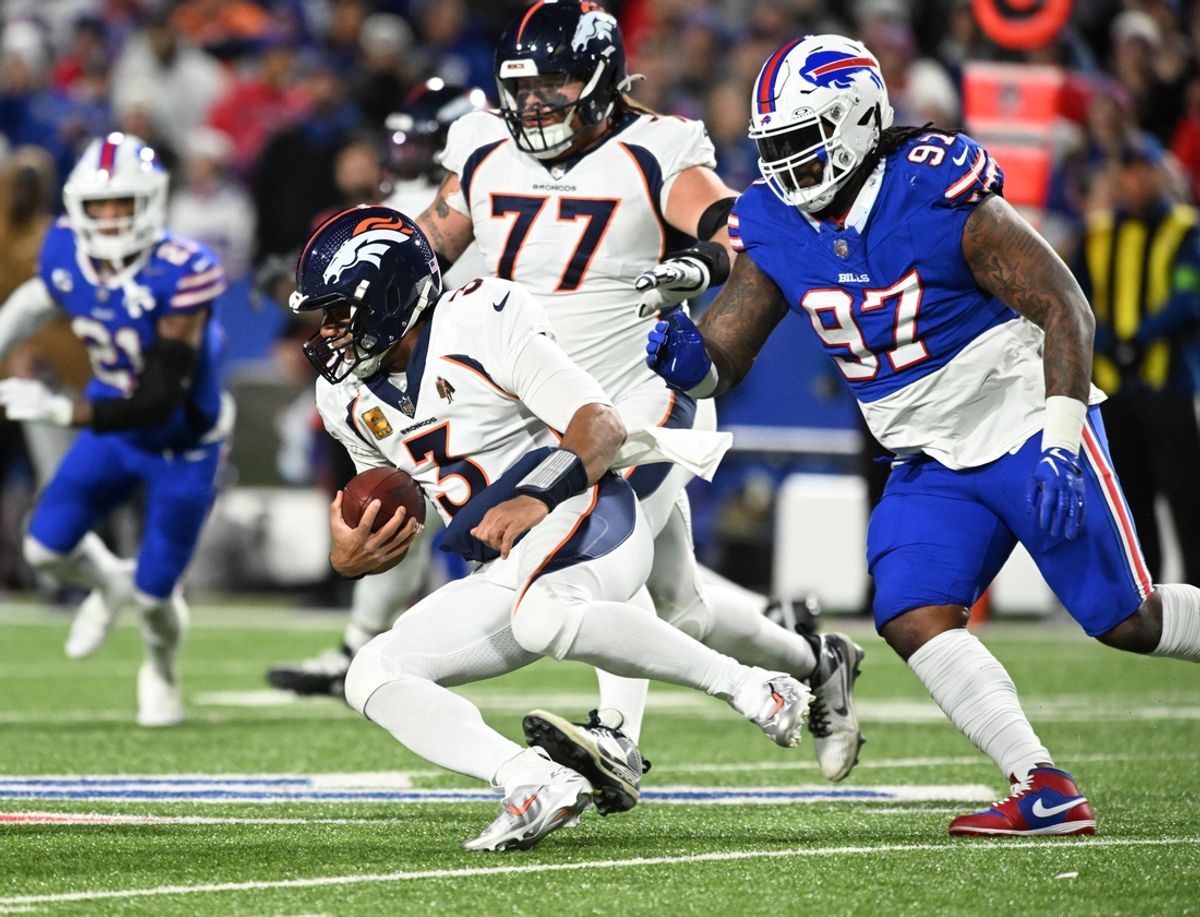 Nov 13, 2023; Orchard Park, New York, USA; Denver Broncos quarterback Russell Wilson (3) runs from Buffalo Bills defensive tackle Jordan Phillips (97) in the first quarter at Highmark Stadium. Mandatory Credit: Mark Konezny-Imagn Images