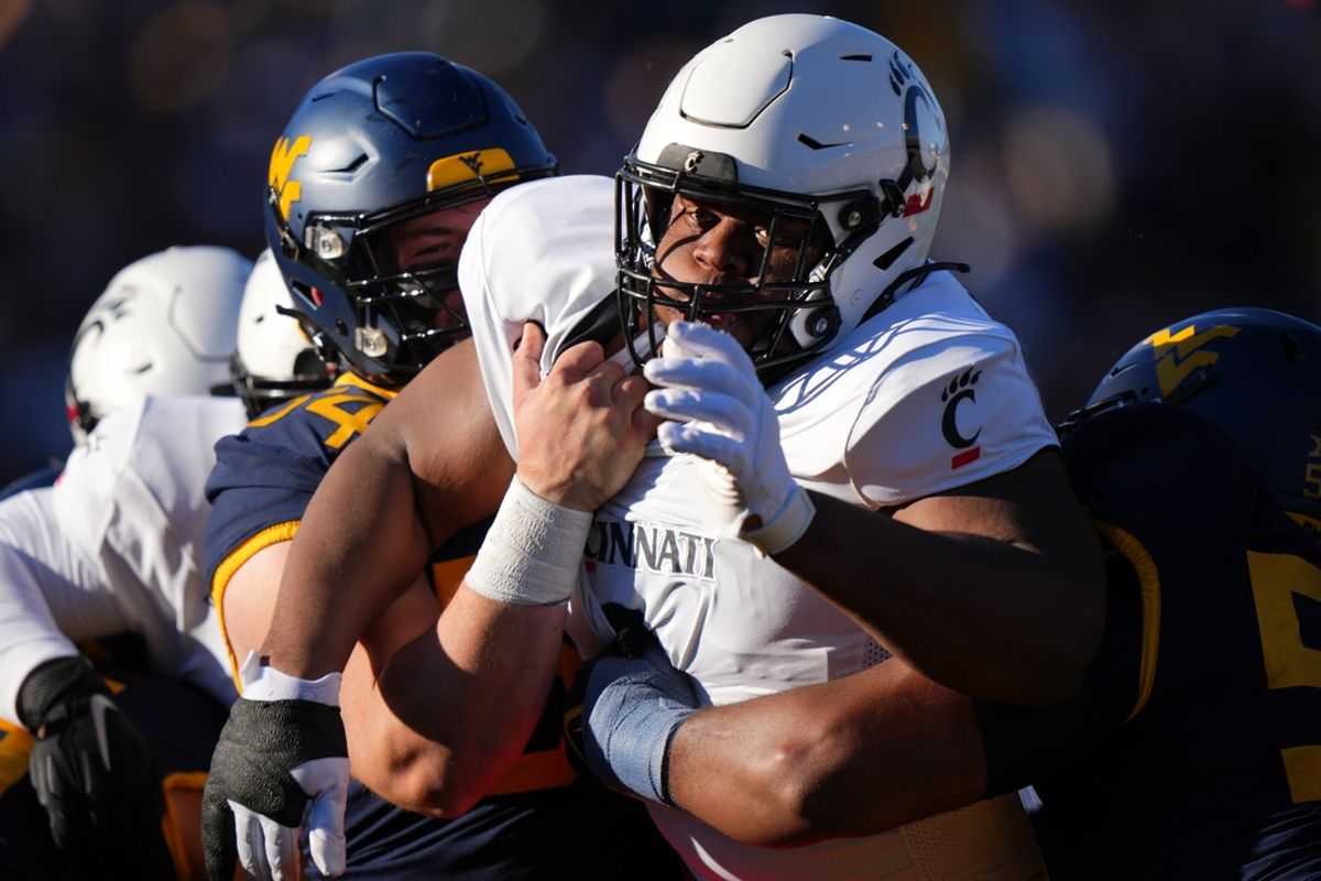 Cincinnati Bearcats defensive lineman Dontay Corleone (2) is double-teamed on a pass rush in the first quarter during an NCAA college football game between the Cincinnati Bearcats and the West Virginia Mountaineers, Saturday, Nov. 18, 2023, at Milan Puskar Stadium in Morgantown, W. Va.