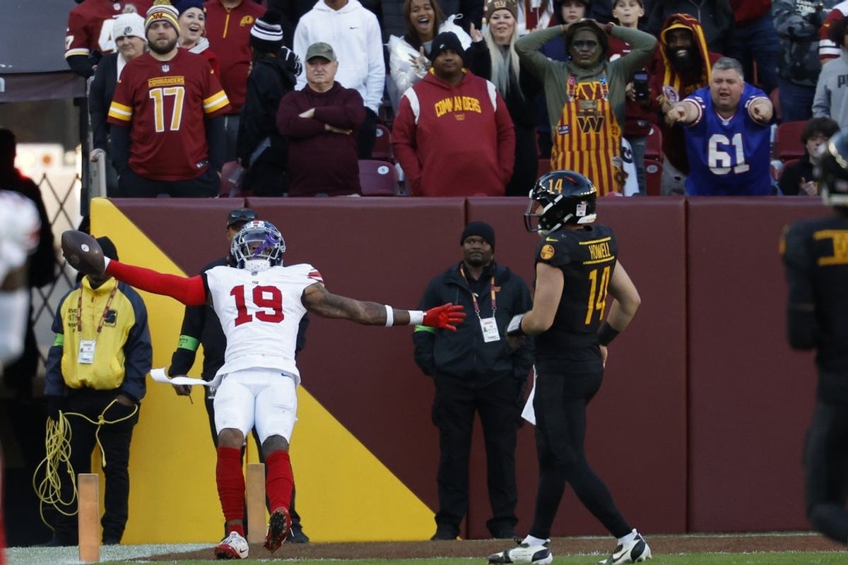 Nov 19, 2023; Landover, Maryland, USA; New York Giants safety Isaiah Simmons (19) celebrates while scoring a touchdown on an interception of Washington Commanders quarterback Sam Howell (14) in the final minute during the fourth quarter at FedExField. Mandatory Credit: Geoff Burke-Imagn Images